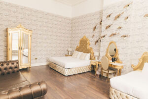 bedroom at rainhill hall showing a wardrobe, dresser table, bed and sofa